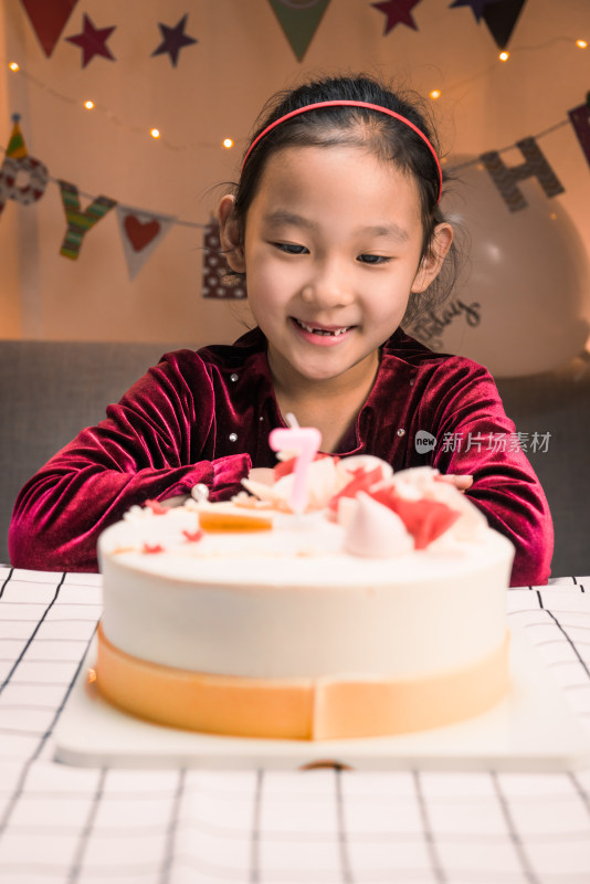 中国女孩对着生日蛋糕许愿吹蜡烛