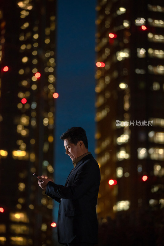 晚上在户外看手机的商务男士