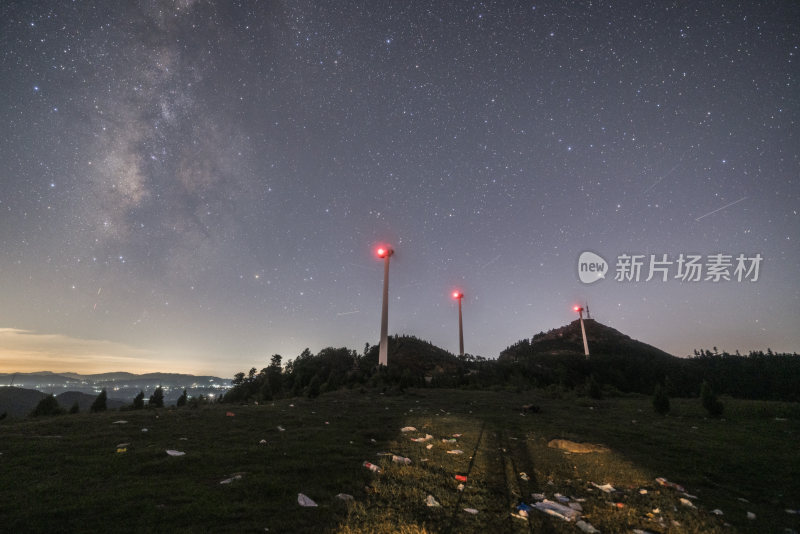 山顶上的星空夜景与风力发电机