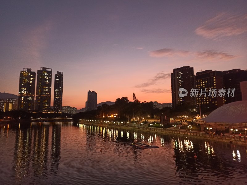 城市河道边高楼林立的黄昏美景