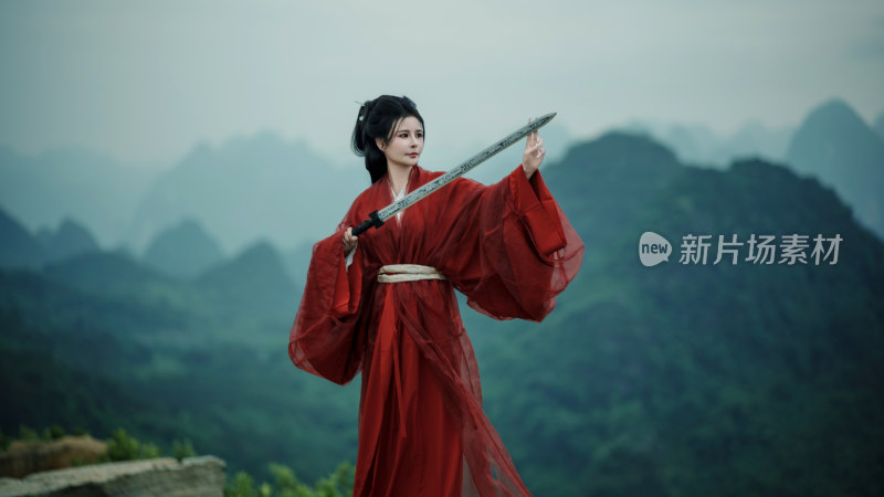 古装女子持剑于山峦前