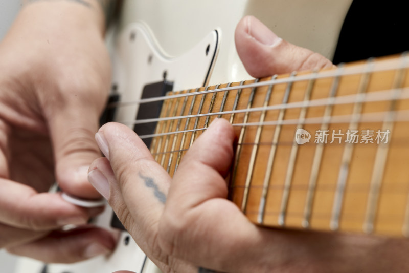 示范演奏摇滚电吉他的亚洲男性乐手人像局部特写
