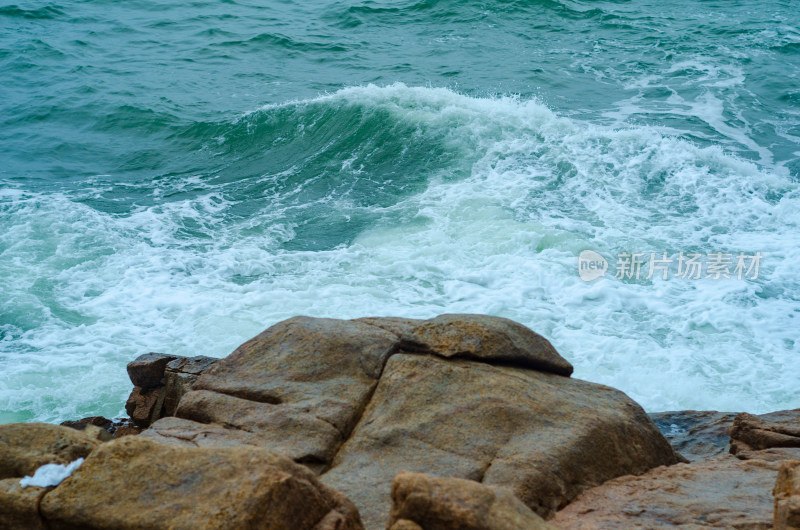 海边面对飞溅的浪花