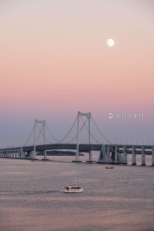 夕阳下大连星海湾大桥上空升起的月亮