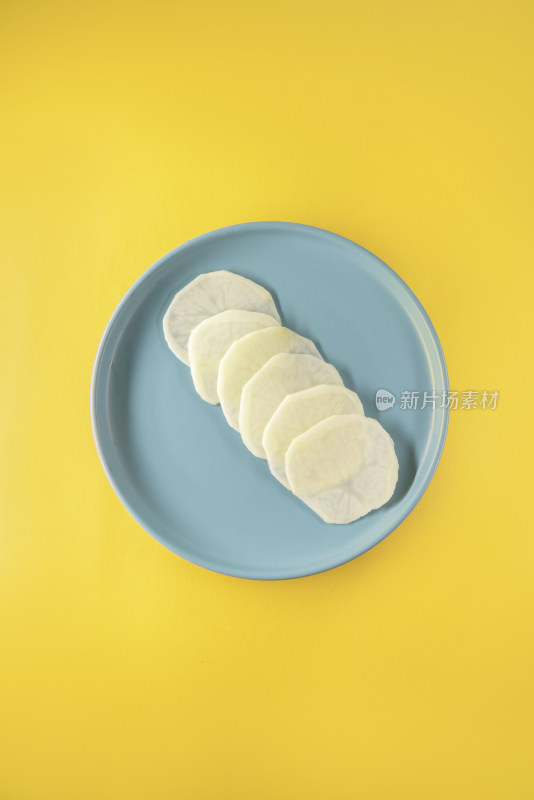 黄色背景中蓝色盘子里的土豆片