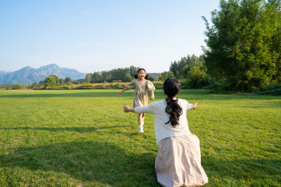 妈妈和女儿在草地上做游戏