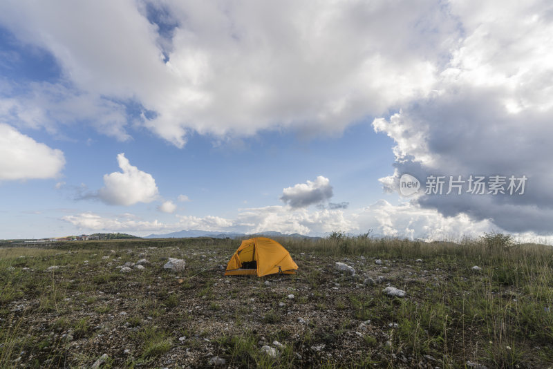 野外草地中放置着一顶黄色帐篷