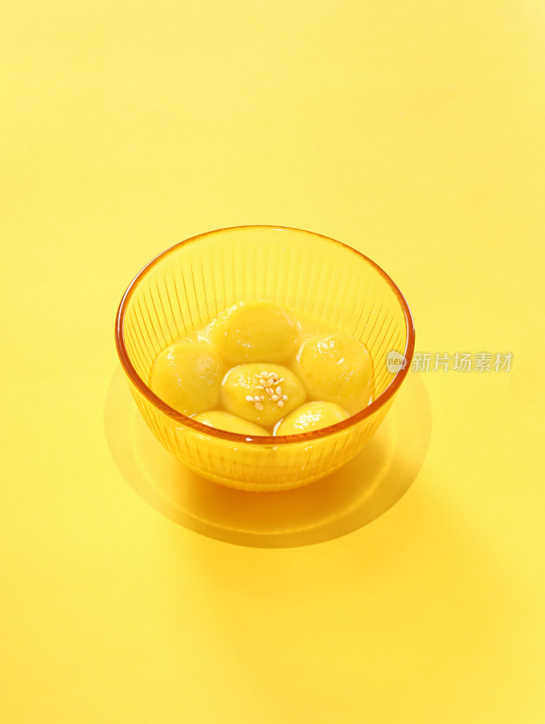 黄色背景上的一碗传统美食汤圆元宵