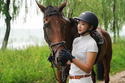 林间小路漂亮的年轻女孩和马