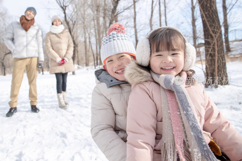 欢乐家庭在雪地上玩雪橇