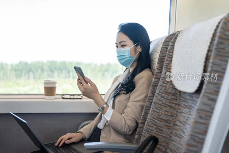 商务女士戴口罩乘坐地铁使用手机