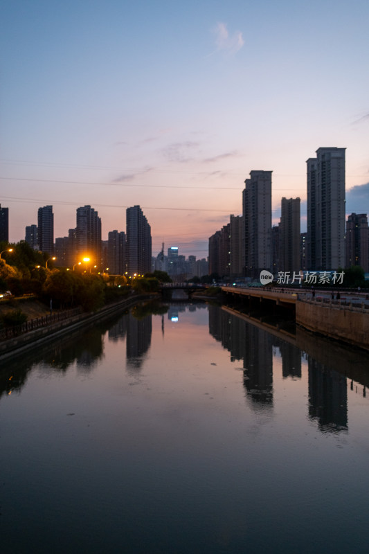 城市河道边高楼林立的黄昏之景