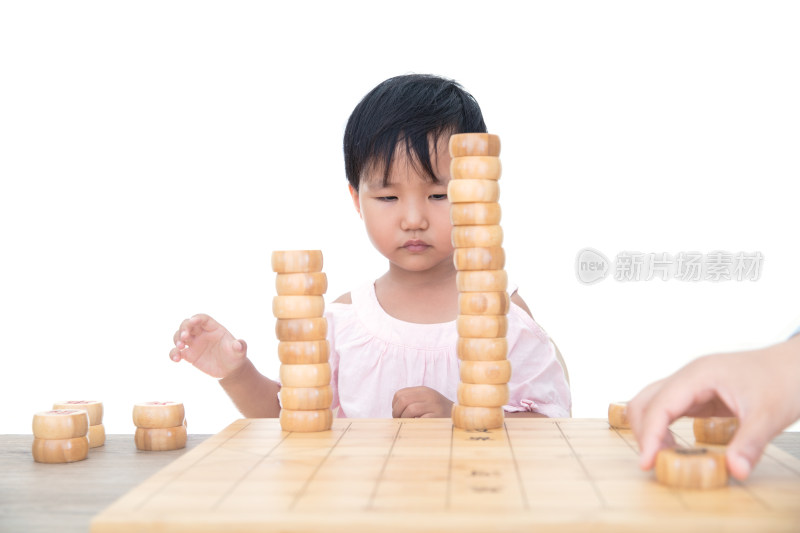 在白背景前的桌子上摞中国象棋棋子