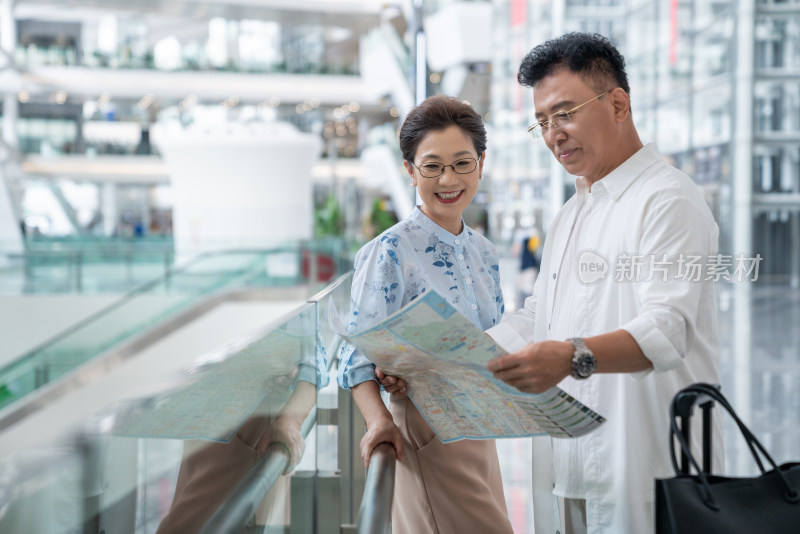 快乐的老年夫妇在机场看地图