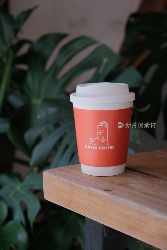 木质桌上的Moles Coffee纸杯