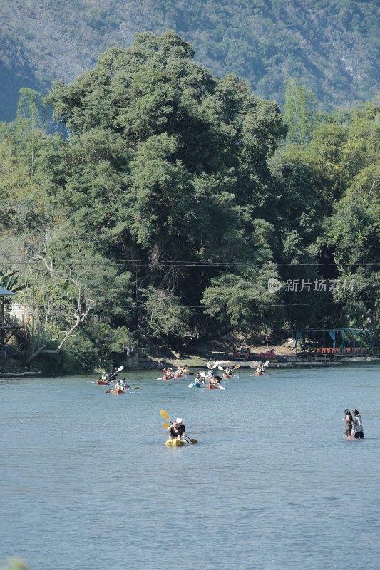 老挝万荣河上多人划艇与山林风景