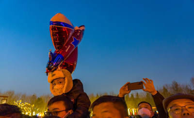 小孩新年坐在爸爸的肩上逛庙会