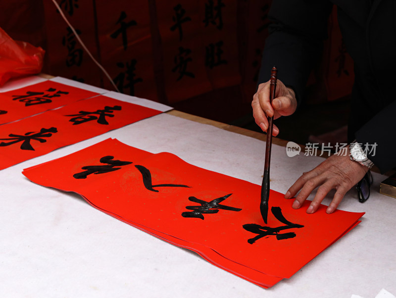 一位老人正在手写春节的传统春联