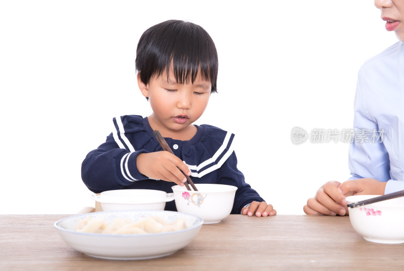 黄皮肤小女孩坐在妈妈身边自主吃饭