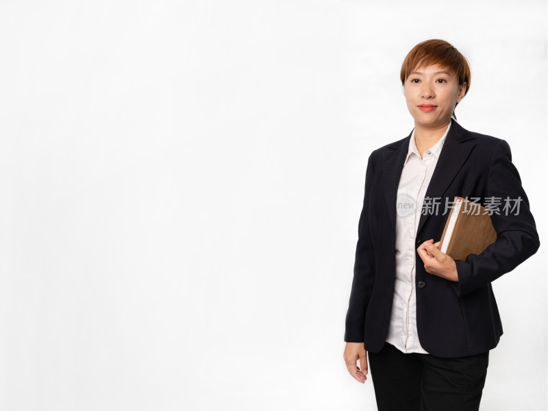 站在白色背景前着职业装拿笔记本的中国女性