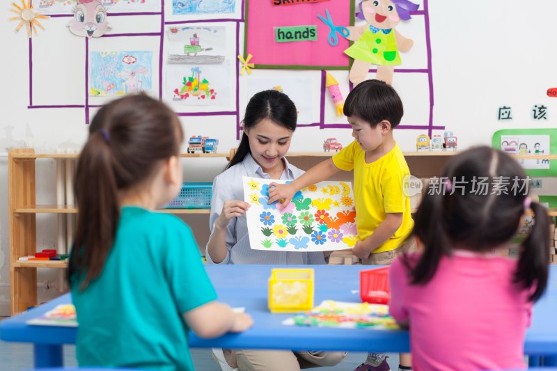 幼儿园女老师和儿童展示手工儿童画