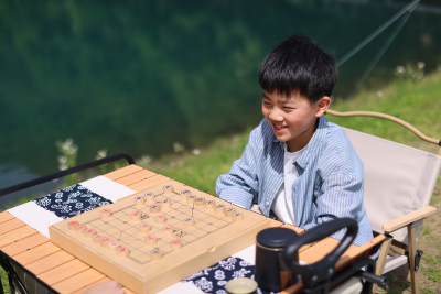 正在野外下棋的中国小男孩