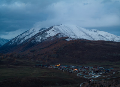 航拍傍晚雪山下的新疆禾木村风景
