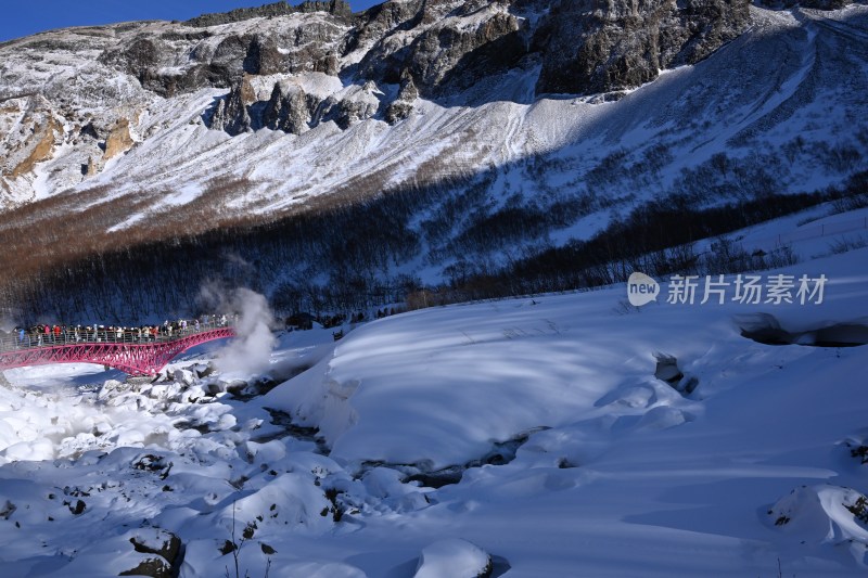 雪山中建有红色桥梁的自然景观