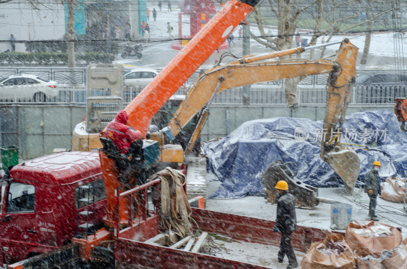 风雪中在卡车上施工的工人