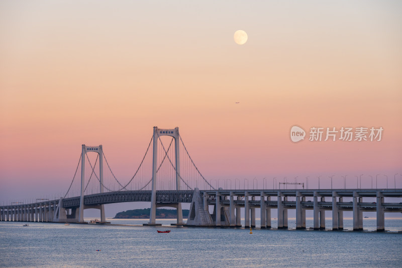 夕阳下大连星海湾大桥上空升起的月亮