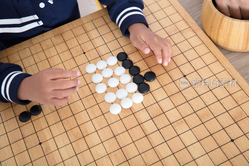 俯视拍摄小手在棋盘上下围棋