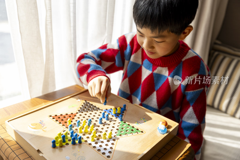 中国小孩在窗边下棋跳跳棋