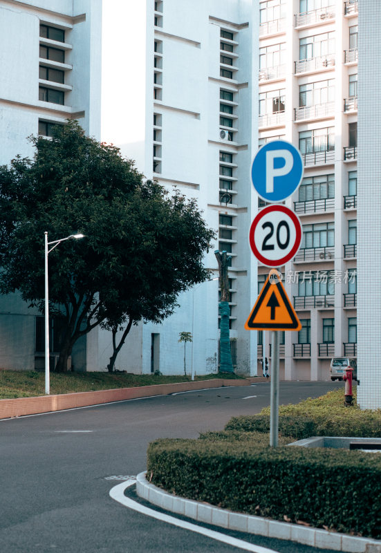 有停车和限速标志的白色建筑旁街道