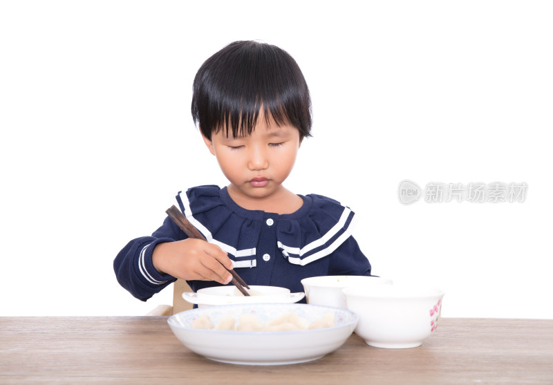 餐桌上一个三岁的中国小女孩在自己吃饭