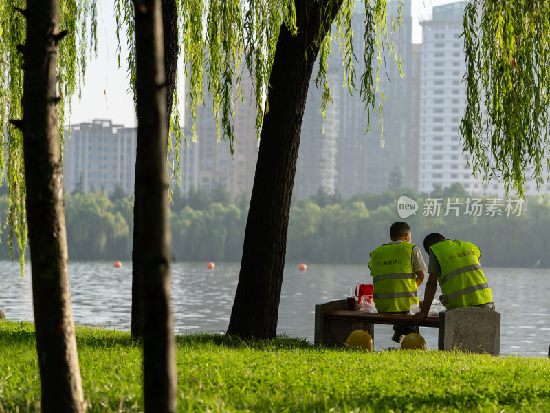 清晨公园里 吃早餐的建筑工人背影