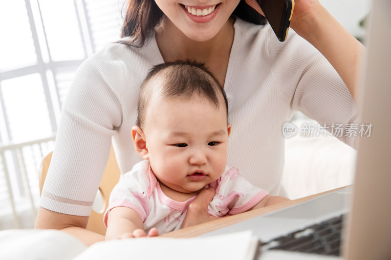 年轻妈妈带着宝宝看电脑