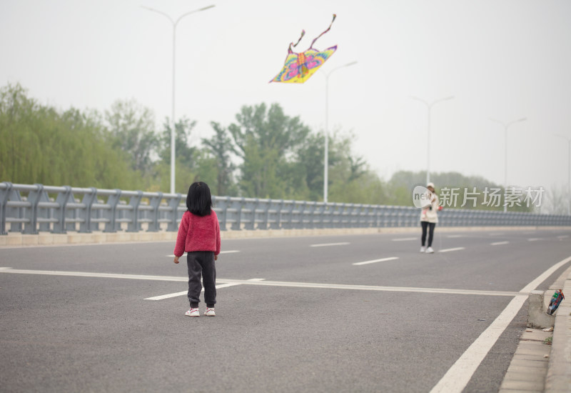 妈妈和女儿在公路上放风筝