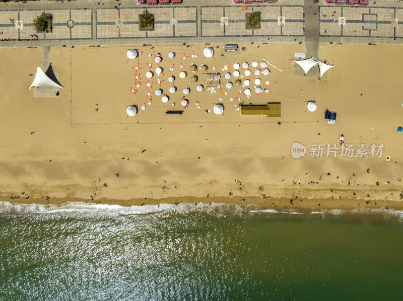 空中俯瞰黄海海滨金沙滩与白色的遮阳伞