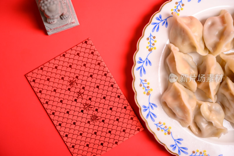 红色背景中国北方春节美食饺子与新年红包