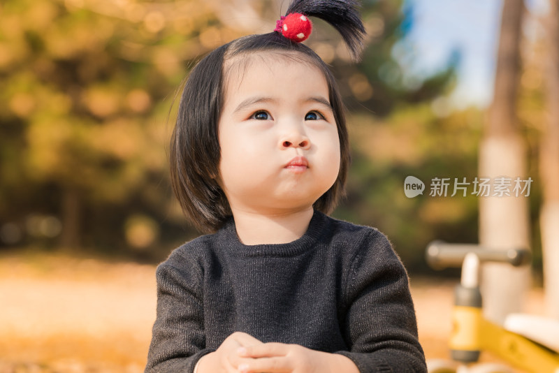 深秋坐在公园落满黄叶的草地上的女孩特写