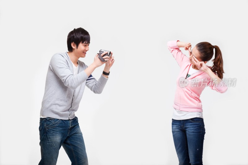 快乐的年轻情侣使用数码摄像机