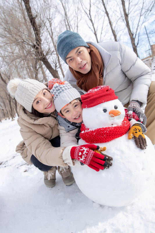 一家三口在雪地里堆雪人