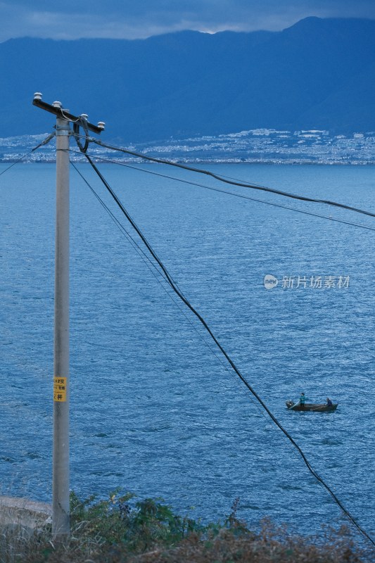 湖边电线杆与湖中小船风景