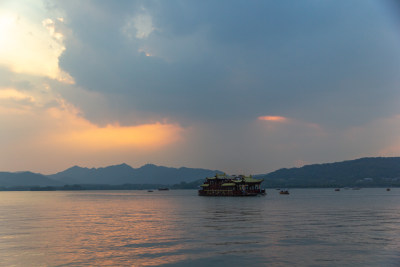 杭州西湖湖面夕阳下的山峦与云彩