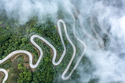 航拍云雾中的蜿蜒盘山路