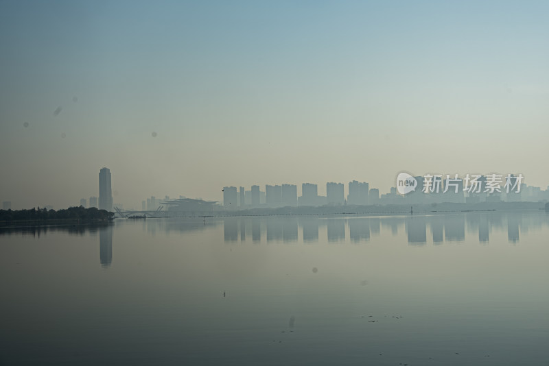 城市天际线倒映在平静湖面上的景象