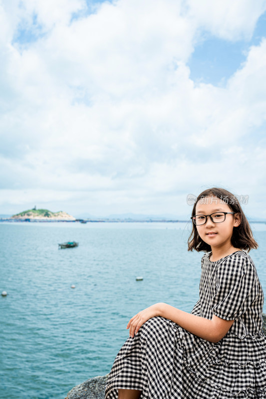 女孩海边石上静坐留影远眺大海