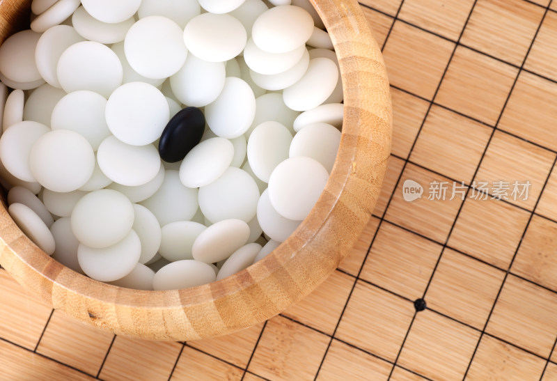 棋盒里一堆白子围绕下的黑子