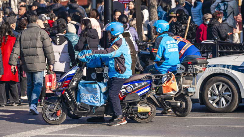 街头身穿蓝色制服的外卖骑手