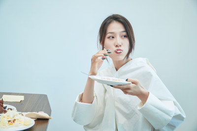 在烘焙店吃蛋糕喝饮料的可爱亚洲少女